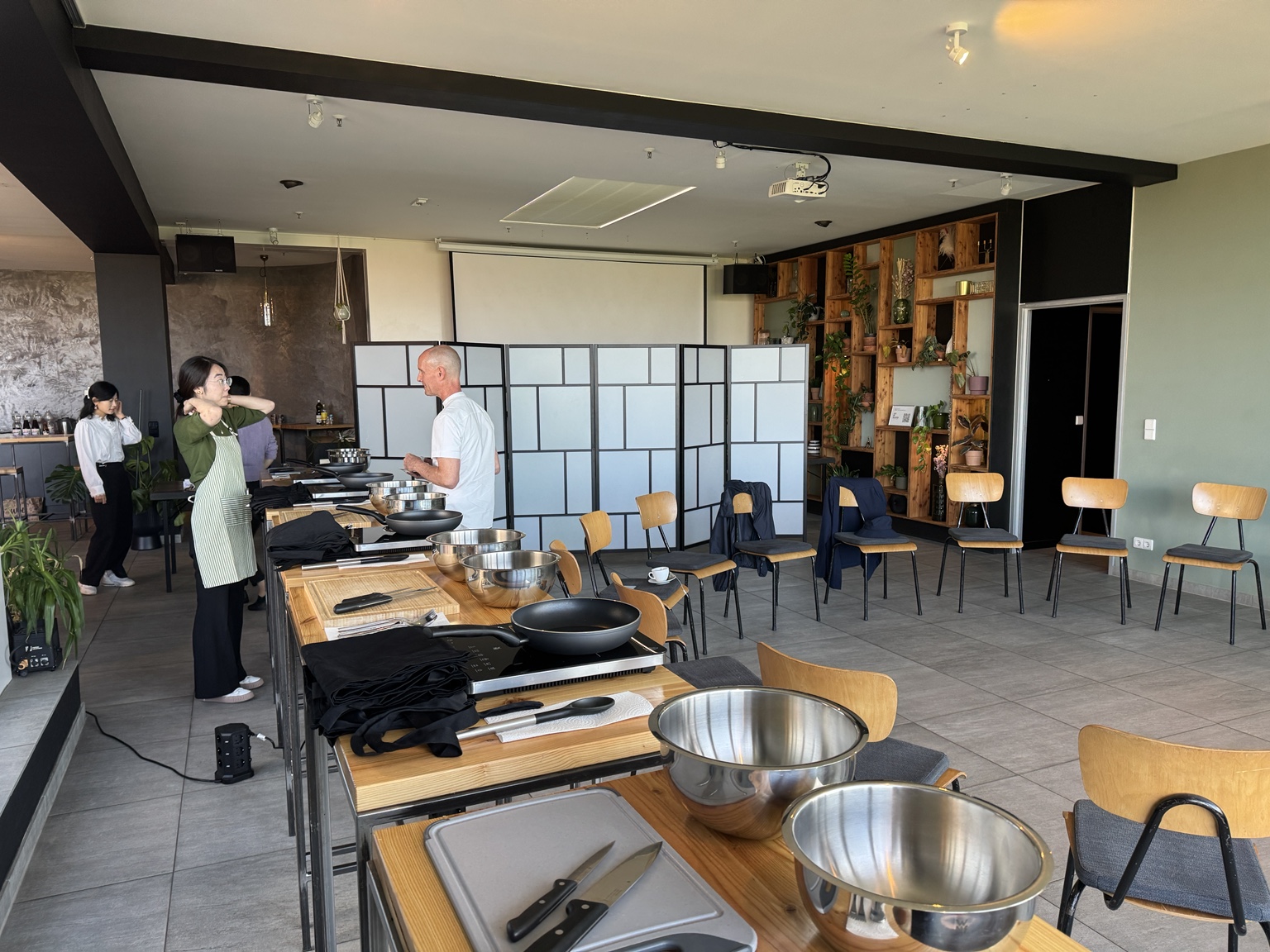Cooking stations set up with pans, steel bowls and chopping boards before the plant-based cooking workshop begins.